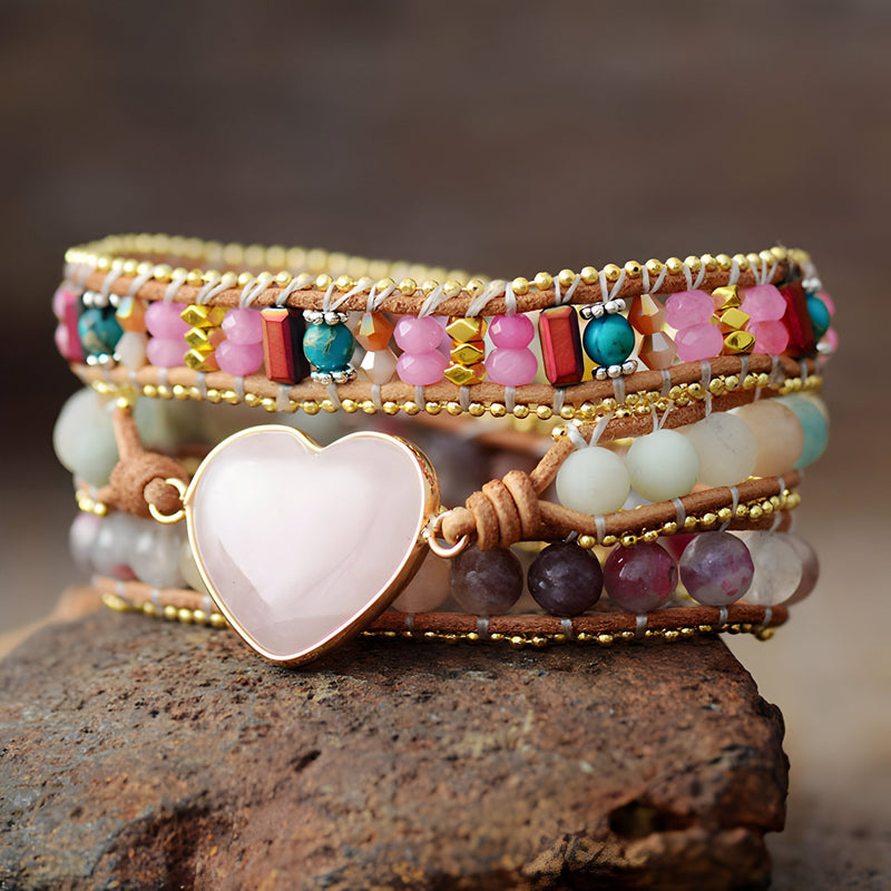 Bracelet multi-rangs en quartz rose, jaspe multicolore et cœur central en quartz rose sur fil beige.