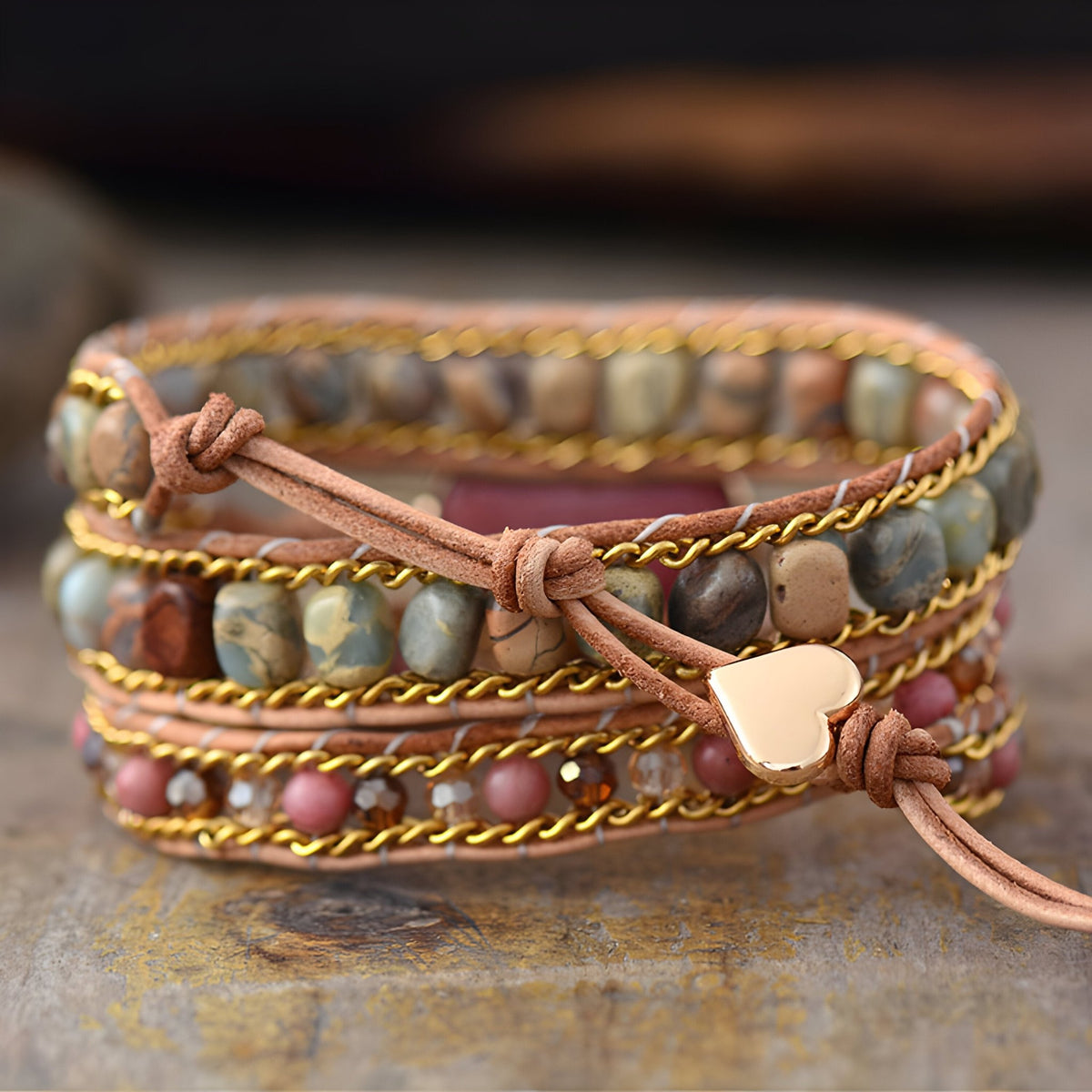 Bracelet multirangs en rhodonite et jaspe avec cœur doré central et lien en cuir rose pâle.