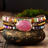Bracelet multi-rangs en pierres naturelles multicolores avec pierre centrale rhodonite rose et jaspe, monté sur cordon.