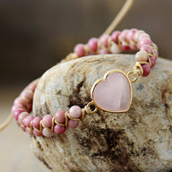 Bracelet femme en rhodonite rose avec pendentif cœur en quartz rose et détails dorés.