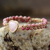 Bracelet femme en rhodonite rose avec cœur en quartz rose serti or, style tissé élégant.