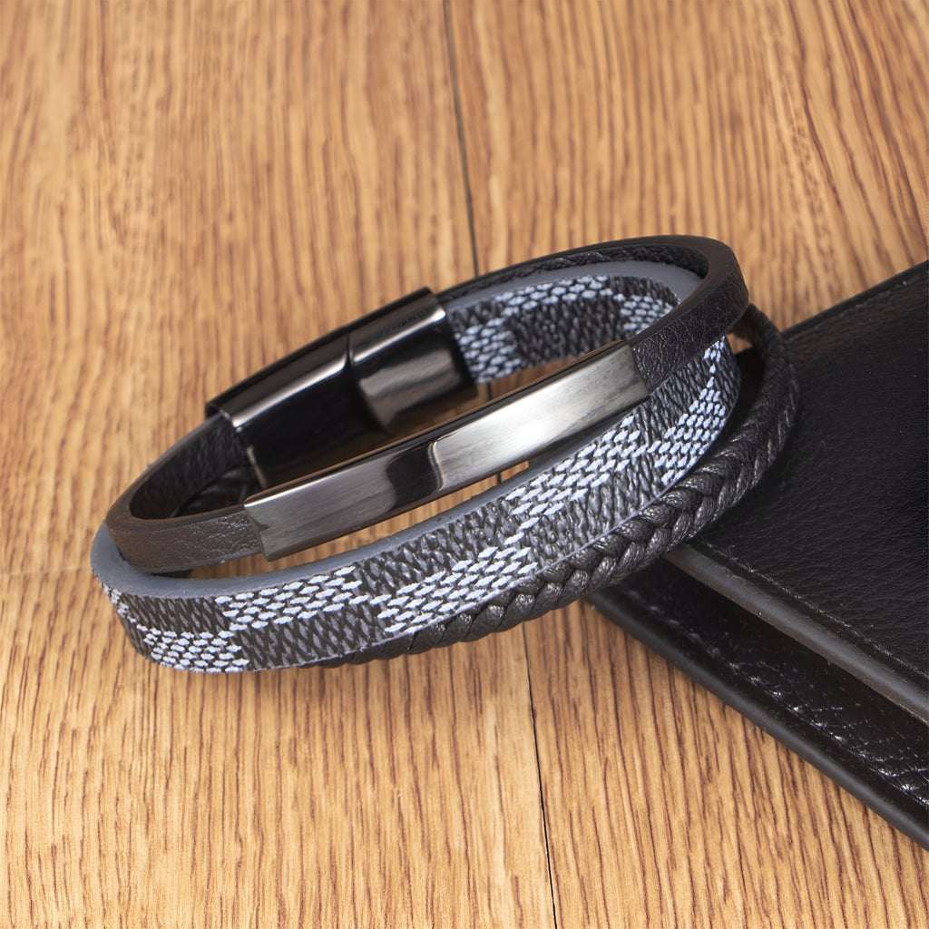 Bracelet multi-rangs gris et noir avec motif damier et fermeture magnétique noire.