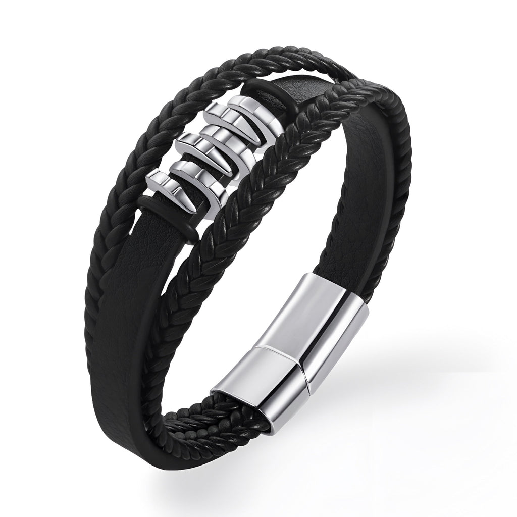 Bracelet multi-rangs noir en cuir tressé avec éléments ondulés en métal argenté et fermoir magnétique.
