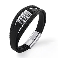 Bracelet multi-rangs noir en cuir tressé avec éléments ondulés en métal argenté et fermoir magnétique.