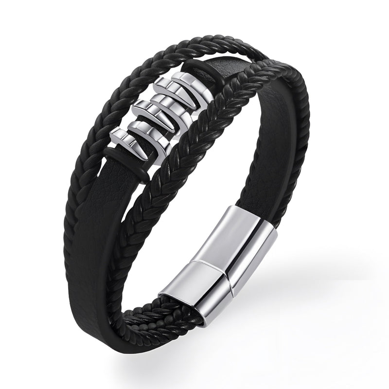 Bracelet multi-rangs noir en cuir tressé avec éléments ondulés en métal argenté et fermoir magnétique.