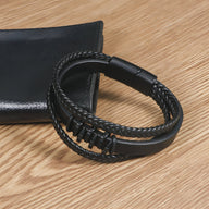 Bracelet multi-rangs en cuir noir tressé avec motif ondulations et fermoir magnétique noir mat.