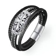 Bracelet multi-rangs noir avec croix détaillée en métal argenté et fermoir magnétique.