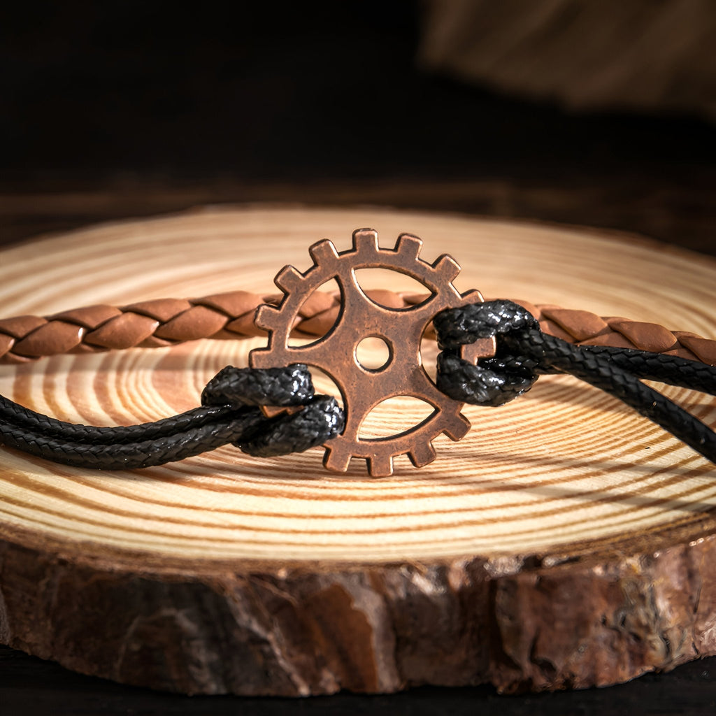 Bracelet multi-rangs homme marron et noir avec gouvernail en métal cuivré sur cordons noirs.