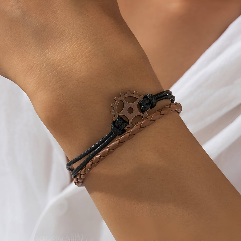 Bracelet multi-rangs marron avec gouvernail en métal noir et cordons tressés pour homme.