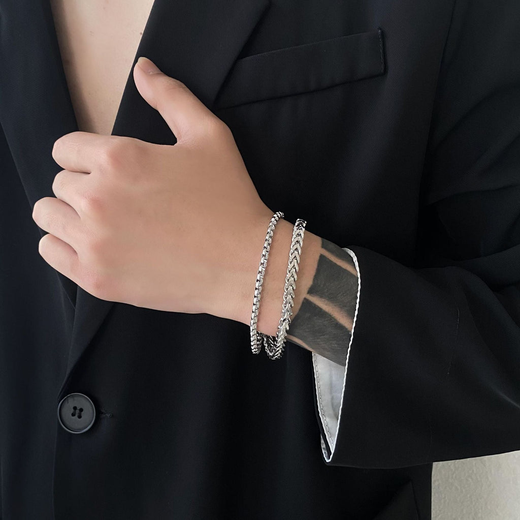 Bracelet double en titane argenté à maille fine porté sur poignet, style masculin élégant.