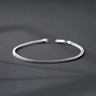 Bracelet fin en titane argenté à maille serrée avec fermoir simple, style masculin.