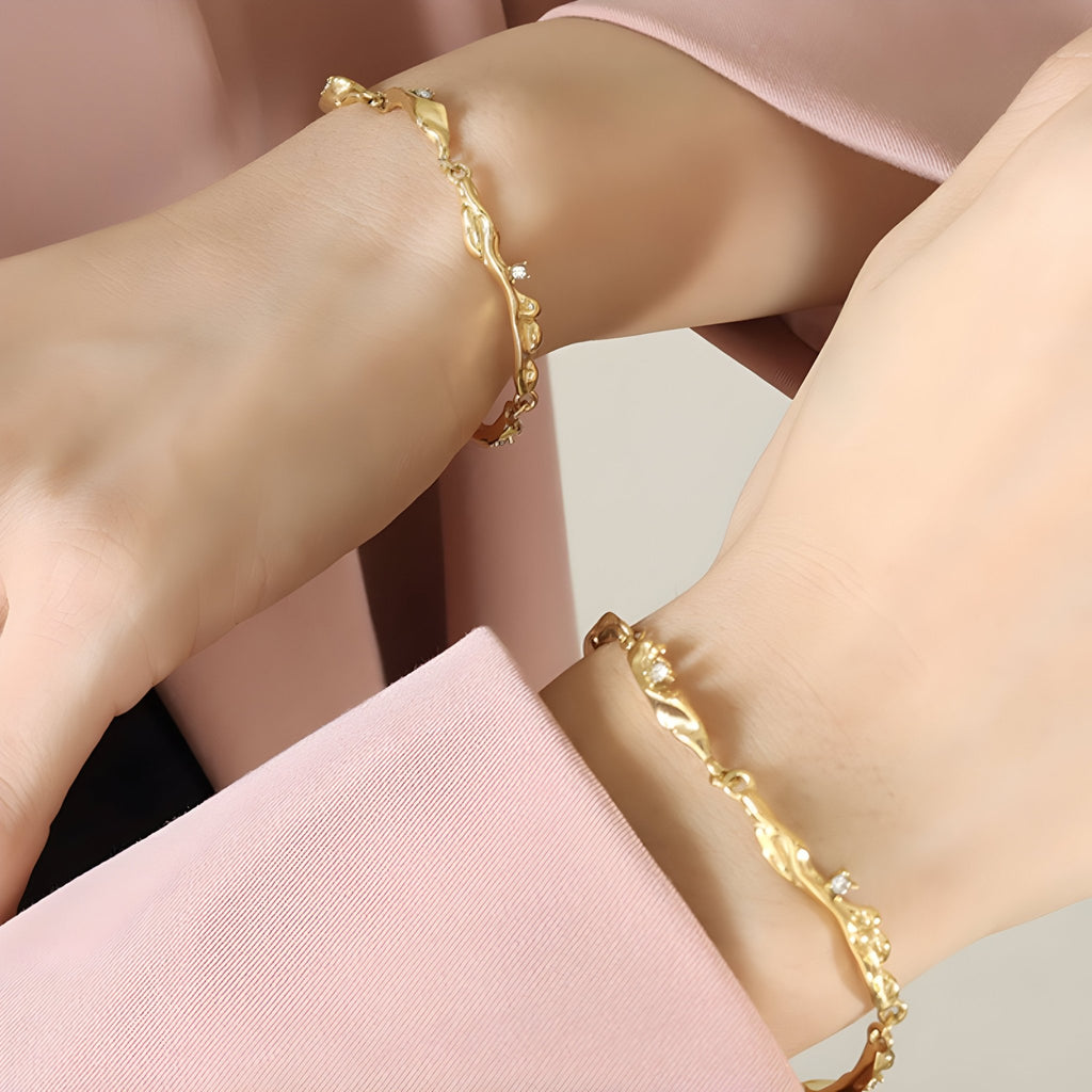 Bracelet femme en titane plaqué or 18 carats avec maillons fluides et zircons scintillants.