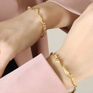 Bracelet femme en titane plaqué or 18 carats avec maillons fluides et zircons scintillants.