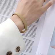 Bracelet tressé en titane plaqué or 18 carats, finition lisse et brillante, modèle Doriane.