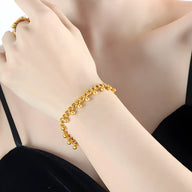 Bracelet en titane plaqué or 18 carats avec petites perles rondes brillant au poignet, style élégant féminin.