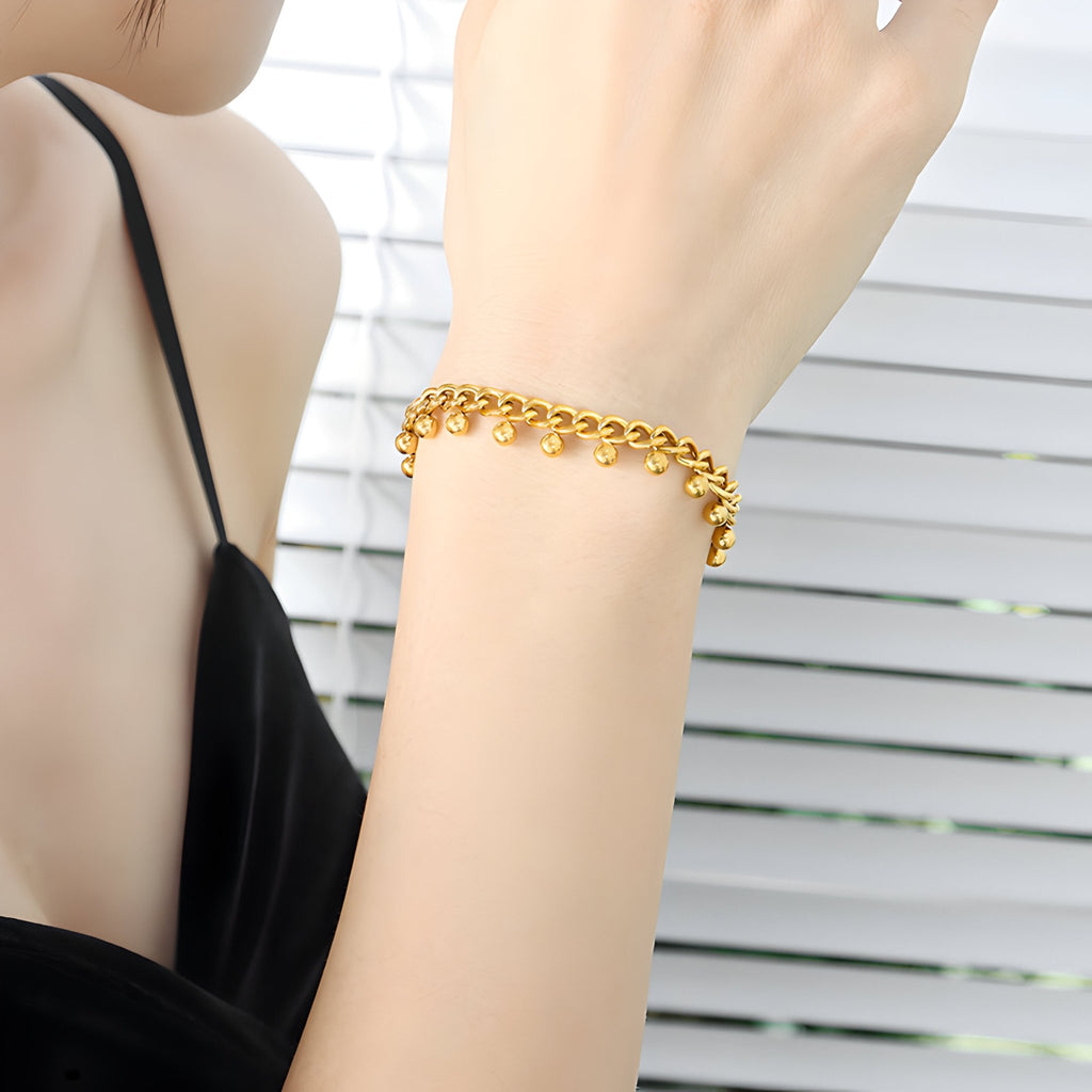 Bracelet en titane plaqué or 18 carats avec maillons ronds élégants porté sur un poignet féminin.