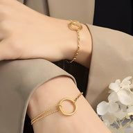 Bracelet fin en titane plaqué or 18 carats avec anneau rond et chaîne double délicate.