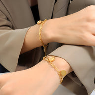 Bracelet en titane plaqué or 18 carats avec chaînes fines et médaillons ronds variés.