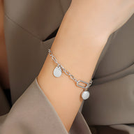 Bracelet chaine en titane plaqué argent avec deux médaillons ronds et fermoir toggle.