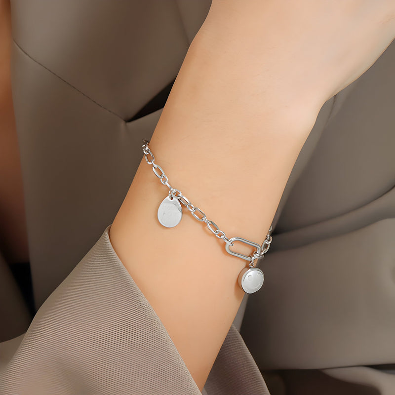 Bracelet chaine en titane plaqué argent avec deux médaillons ronds et fermoir toggle.