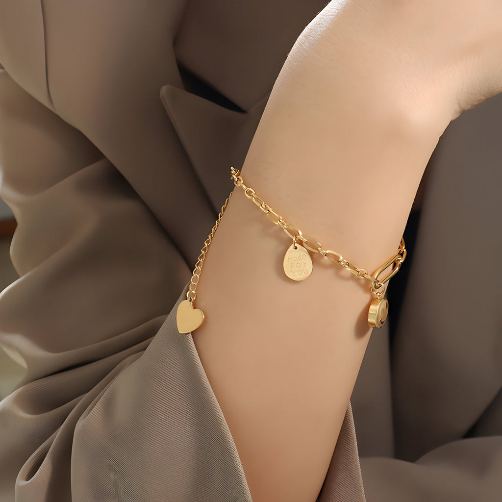 Bracelet chaîne en titane plaqué or 18 carats avec médaillons cœurs et cercle.