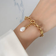 Bracelet en titane plaqué or 18 carats avec large perle naturelle pendante, style chaîne élégante.