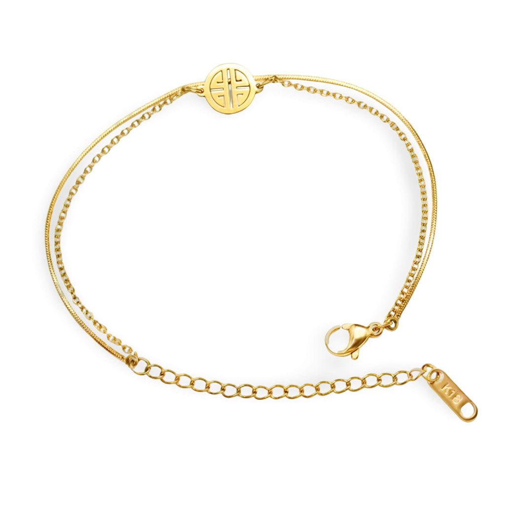 Bracelet fin en titane plaqué or 18 carats avec médaillon rond à motif géométrique et chaîne ajustable.