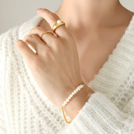 Bracelet en titane plaqué or 18 carats avec perles naturelles blanches finition brillante.