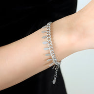 Bracelet en titane argenté avec chaîne maille gourmette et petits médaillons suspendus.