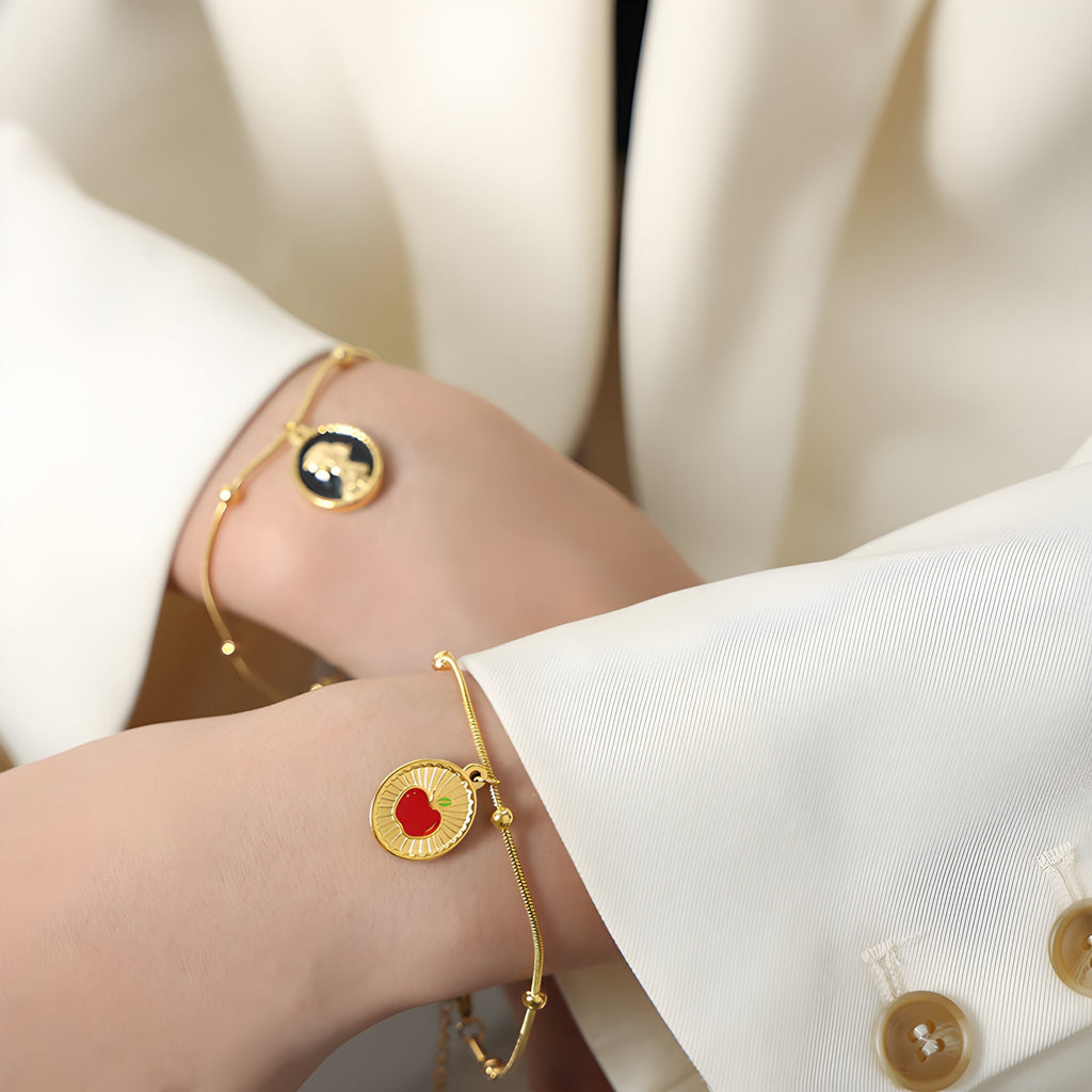 Bracelet en titane plaqué or 18 carats avec pendentifs Blanche Neige noir et pomme rouge élégants.