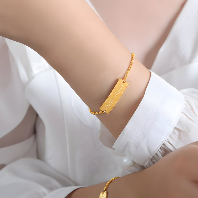 Bracelet en titane plaqué or 18 carats avec plaque gravée "Happy Forever" sur chaîne fine réglable.