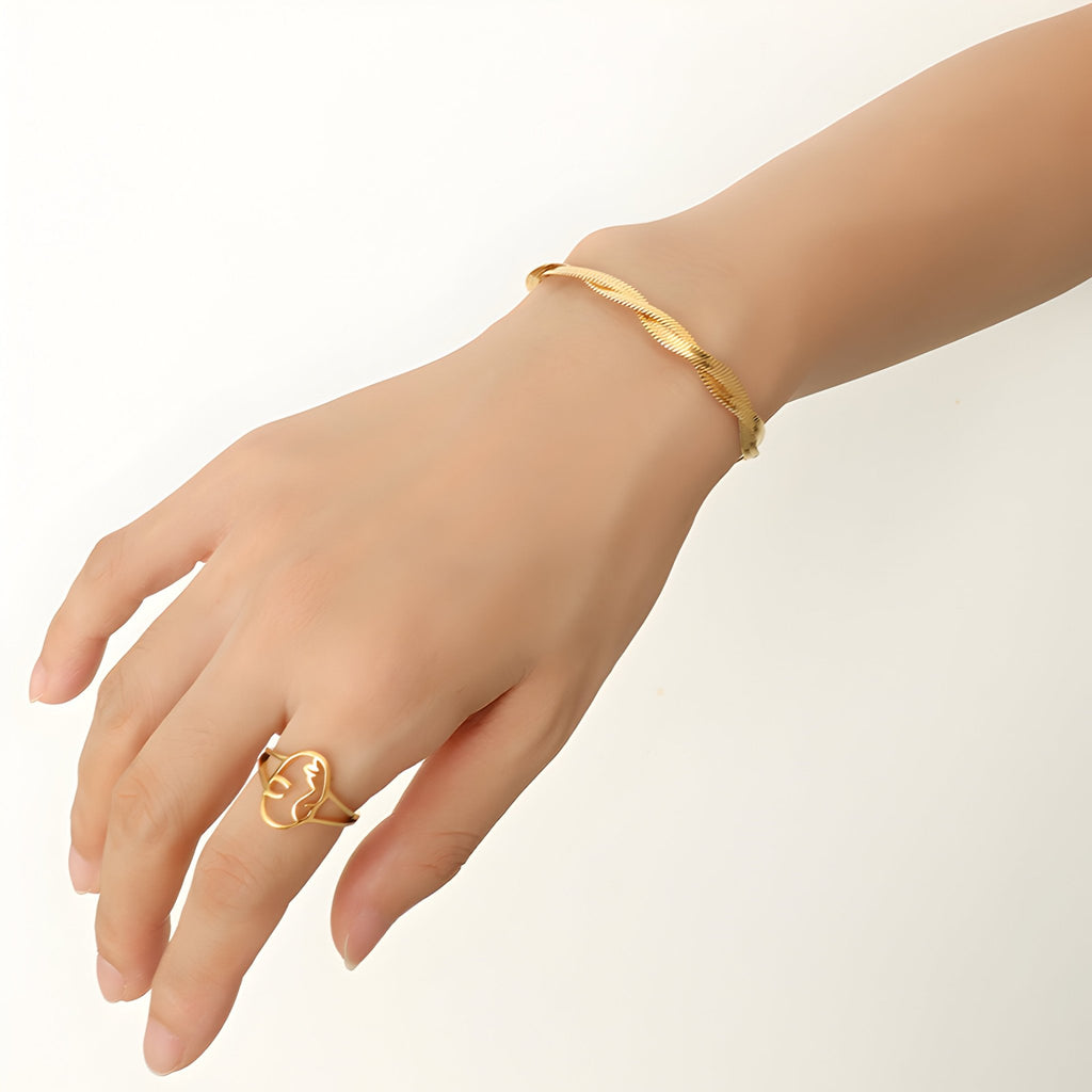 Bracelet en titane doré 18 carats avec maille enroulée élégante porté au poignet féminin.
