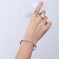 Bracelet fin en titane or 18 carats avec motif étoiles creuses, modèle Julie, porté au poignet.