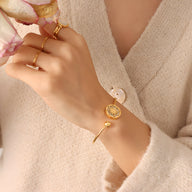 Bracelet rigide plaqué or 18 carats avec médaille florale élégante, modèle Léa.