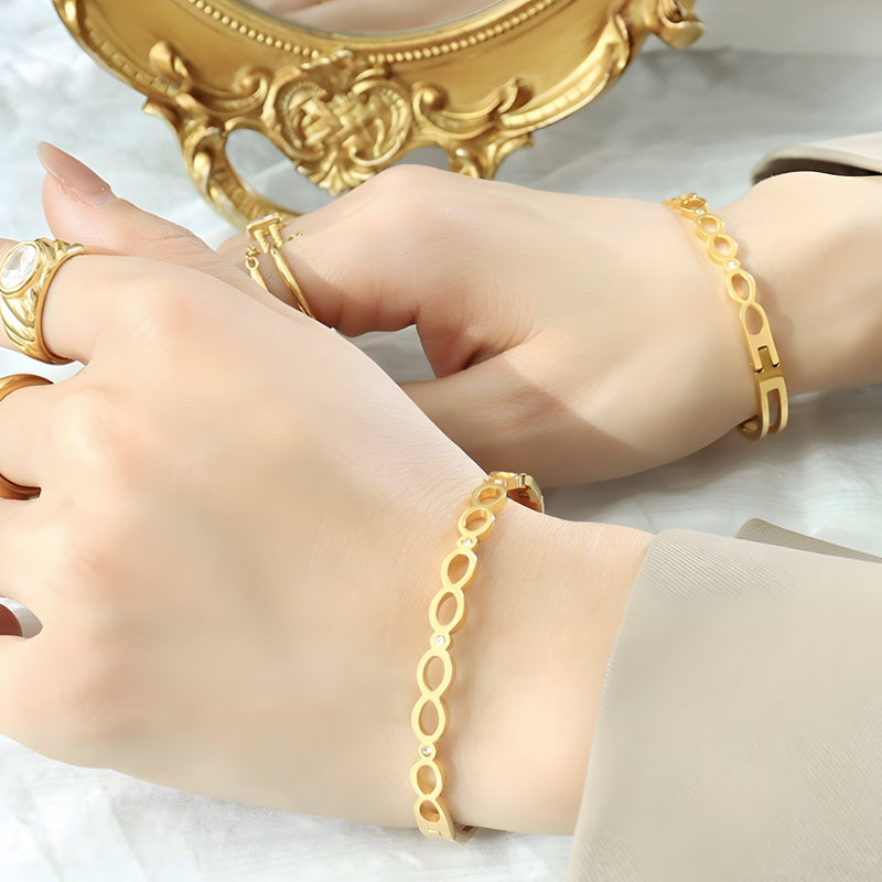 Bracelet fin en titane plaqué or 18 carats avec motif infini ajouré au poignet féminin.