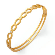 Bracelet rigide en titane plaqué or 18 carats avec motif infini et pierres de zircon étincelantes.