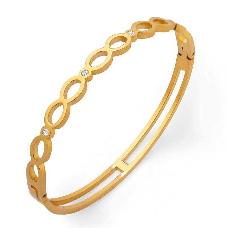 Bracelet rigide en titane plaqué or 18 carats avec motif infini et pierres de zircon étincelantes.