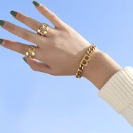 Bracelet en titane plaqué or 18 carats avec motif lettre "B" porté au poignet, style chaîne épaisse.