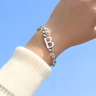 Bracelet en titane argenté avec motif lettre "B", chaîne maille épaisse, style moderne.