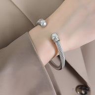 Bracelet jonc en titane argenté torsadé avec extrémités sphériques lisses polishées.