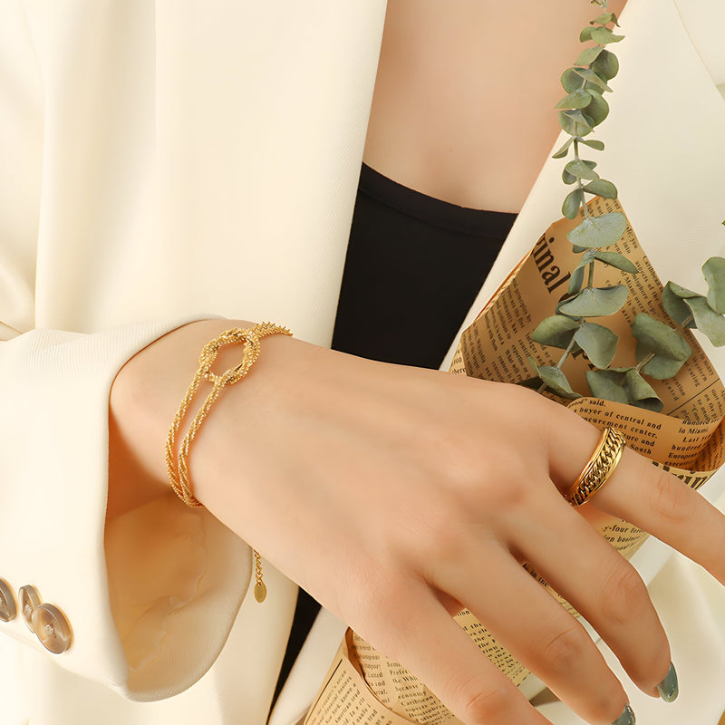 Bracelet en titane plaqué or tressé fin porté au poignet, style élégant et moderne.