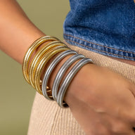 Bracelets joncs flexibles en titane plaqué or et argent, style Mossie, portés au poignet féminin.