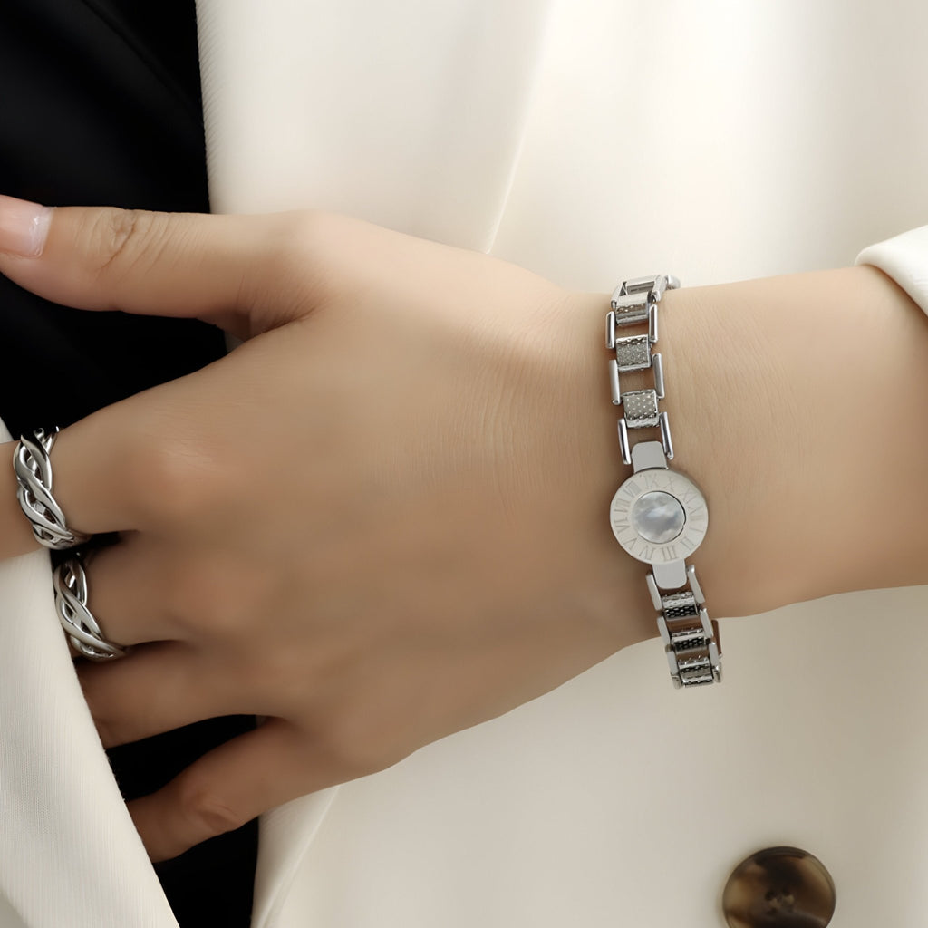 Bracelet en titane plaqué argent avec cadran imitation chiffres romains sur poignet féminin.