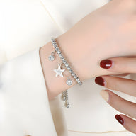 Bracelet en titane argenté avec perles et médaillon étoile ajouré, style délicat et féminin.