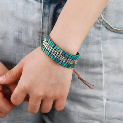 Bracelet multi-rangs en turquoises bleues et perles métalliques, motif floral, style bohème chic.