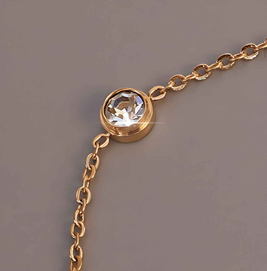 Bracelet fin en titane plaqué or avec diamant rond serti et chaîne délicate.