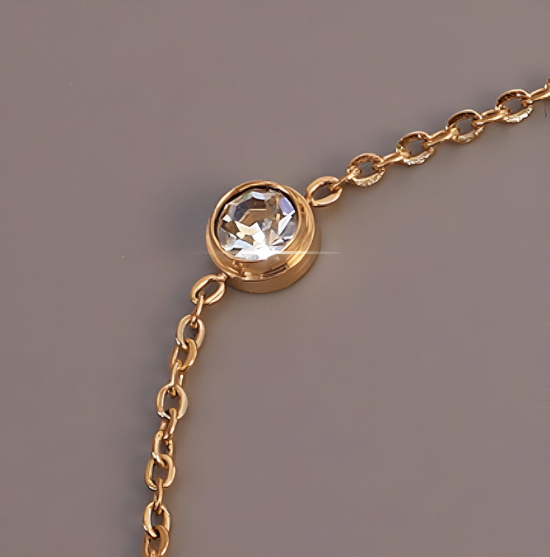 Bracelet fin en titane plaqué or avec diamant rond serti et chaîne délicate.