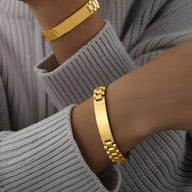 Bracelet gourmette en titane plaqué or style montre avec maillons larges et plaque lisse.