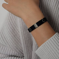 Bracelet gourmette noir en titane plaqué or style montre avec maillons fins et fermoir discret.