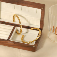 Bracelet jonc or fin orné de petites perles blanches, style élégant et minimaliste.